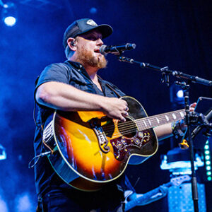 Luke Combs mit Gitarre singt während eines Konzerts