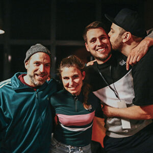 Die Band Neonschwarz halten sich im Arm und schauen in die Kamera