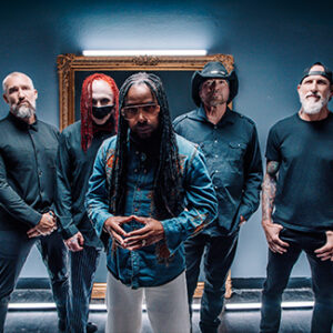 Die Band Sevendust steht vor einem blauen Hintergrund und blickt in die Kamera